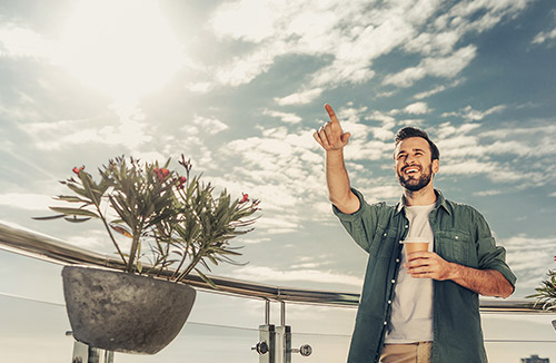 Person pointing with coffee cup in hand